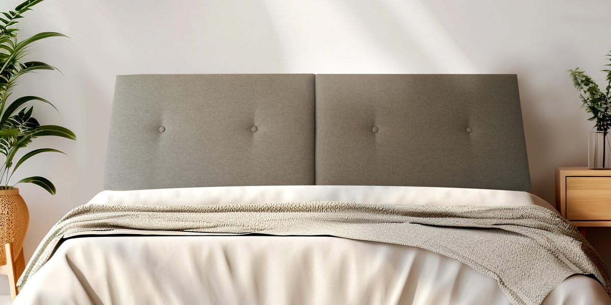 Graues gepolstertes Kopfteil mit Holzablage an einer Wand.