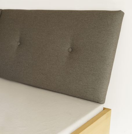 Graues Bettkopfteil mit Knöpfen und verstellbarer Schräge.