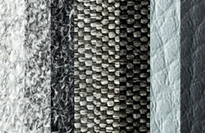 Kunstleder, Webstoff und Wollstoff in verschiedenen Grautönen.